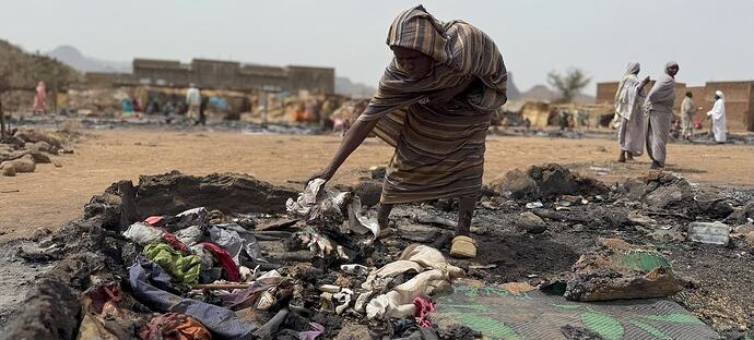 A Sudanese woman at her burned house