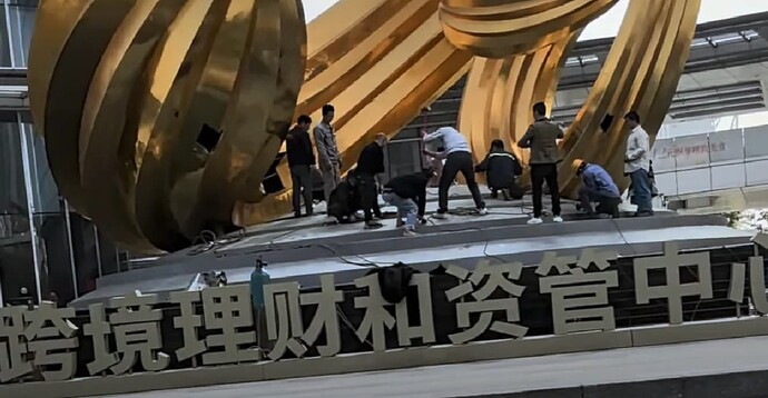 Guangdong Guangzhou Nansha District construction workers smashing a giant golden sculpture outside Yuexiu Financial Center | 690x358