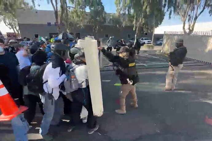 Protesters in Tucson behind shields, throwing paint and heavy objects at security